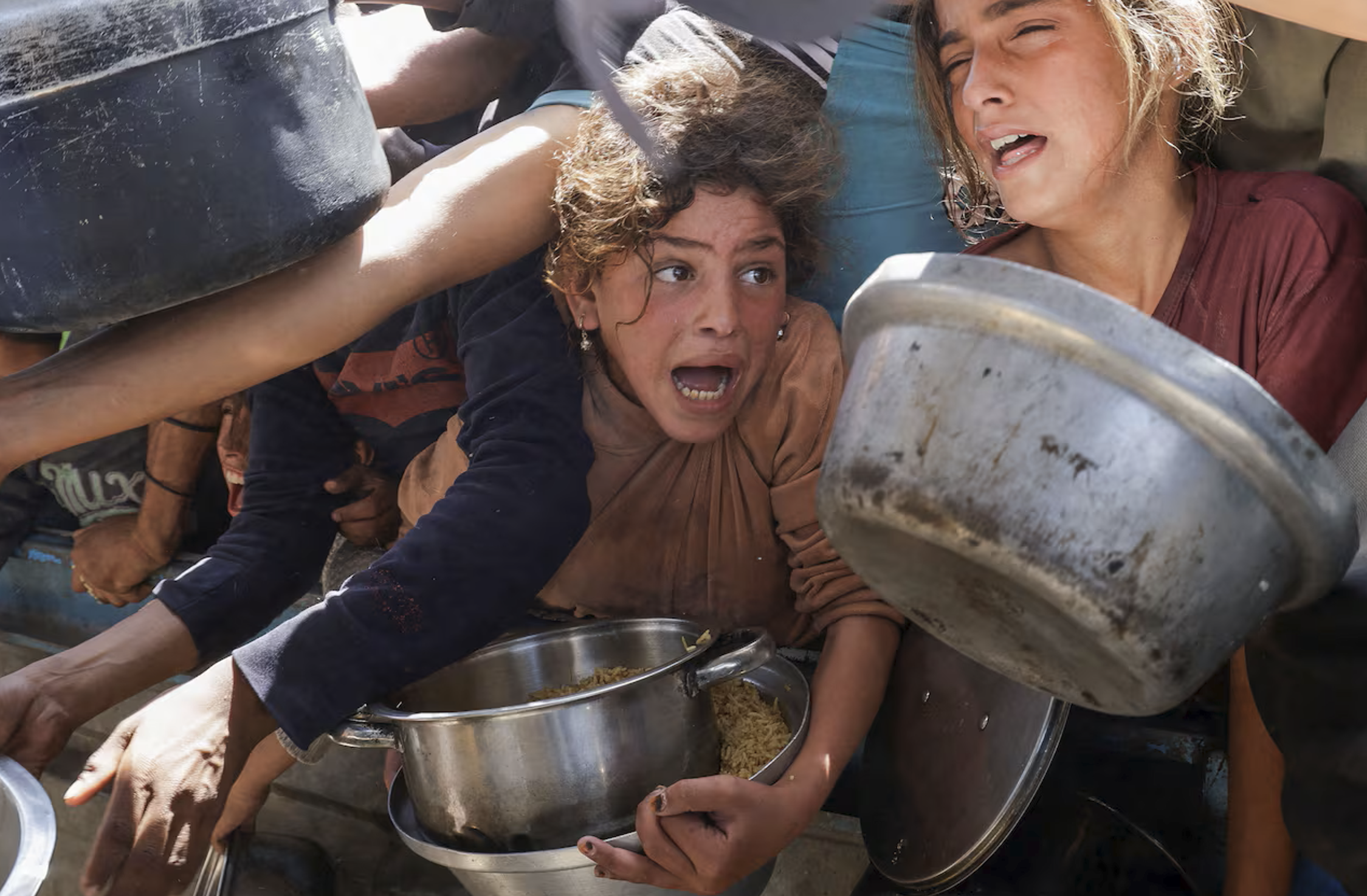people struggling to get food handed out by a charity group